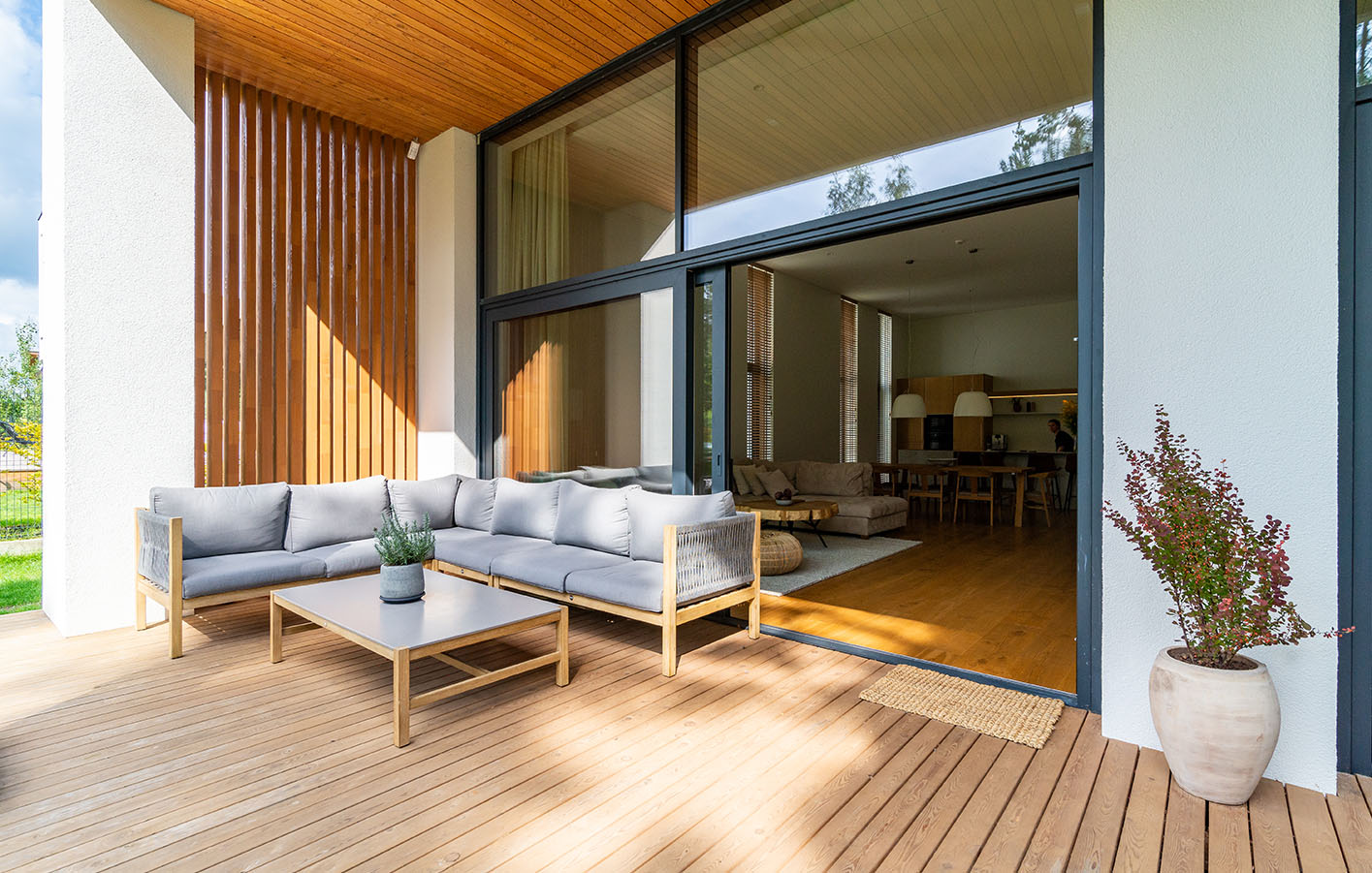 Blick auf Terrasse mit moderner Holzfassade und eleganten Terrassenmöbeln